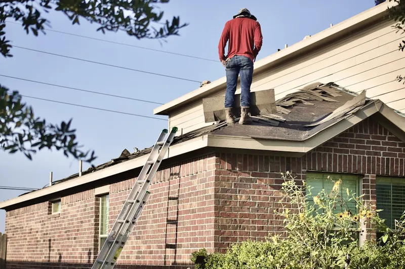 Professional roofer working on a residential roof in Valmy